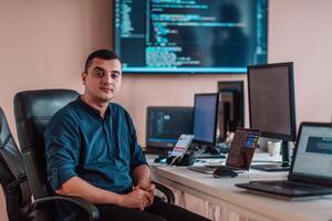 A programmer diligently testing smartphone applications while sitting in their office. photo