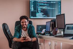 A programmer diligently testing smartphone applications while sitting in their office. photo