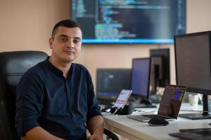 A programmer diligently testing smartphone applications while sitting in their office. photo
