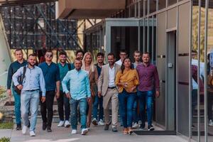 A diverse group of businessmen and colleagues walking together by their workplace, showcasing collaboration and teamwork in the company. photo