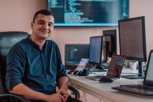 A programmer diligently testing smartphone applications while sitting in their office. photo