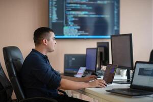 A programmer diligently testing smartphone applications while sitting in their office. photo