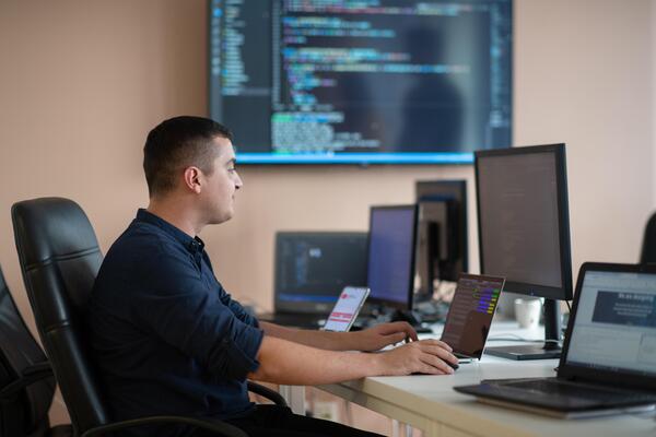 A programmer diligently testing smartphone applications while sitting in their office.