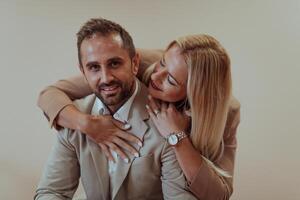 A business couple posing for a photograph together against a beige backdrop, capturing their professional partnership and creating a timeless image of unity and success. photo