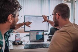 Programmers engrossed in deep collaboration, diligently working together to solve complex problems and develop innovative mobile applications with seamless functionality. photo