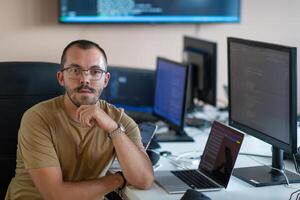 A programmer diligently testing smartphone applications while sitting in their office. photo