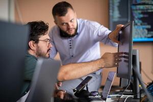 Programmers engrossed in deep collaboration, diligently working together to solve complex problems photo