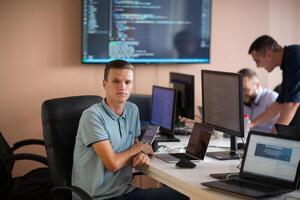 Innovating the Future. A Young Programmer Testing New Smartphone Apps in the Office. photo