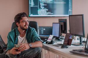 A programmer diligently testing smartphone applications while sitting in their office. photo