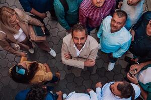 A top view photo of group of businessmen and colleagues standing together, looking towards the camera, symbolizing unity and teamwork.