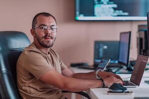 A programmer diligently testing smartphone applications while sitting in their office. photo