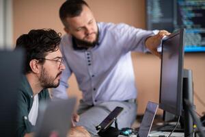 Programmers engrossed in deep collaboration, diligently working together to solve complex problems photo