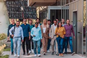 A diverse group of businessmen and colleagues walking together by their workplace, showcasing collaboration and teamwork in the company. photo