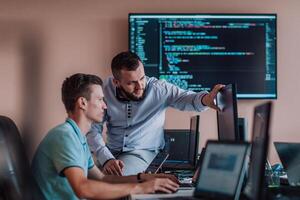Programmers engrossed in deep collaboration, diligently working together to solve complex problems and develop innovative mobile applications with seamless functionality. photo