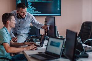 Programmers engrossed in deep collaboration, diligently working together to solve complex problems and develop innovative mobile applications with seamless functionality. photo
