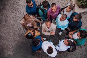 A top view photo of group of businessmen and colleagues standing together, looking towards the camera, symbolizing unity and teamwork.
