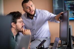 Programmers engrossed in deep collaboration, diligently working together to solve complex problems photo