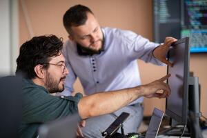 Programmers engrossed in deep collaboration, diligently working together to solve complex problems photo