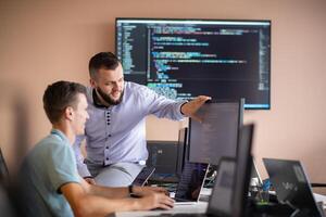 Programmers engrossed in deep collaboration, diligently working together to solve complex problems photo