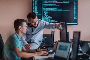 Programmers engrossed in deep collaboration, diligently working together to solve complex problems and develop innovative mobile applications with seamless functionality. photo