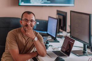 A programmer diligently testing smartphone applications while sitting in their office. photo