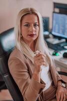 A businesswoman sitting in a programmer's office surrounded by computers, showing her expertise and dedication to technology. photo