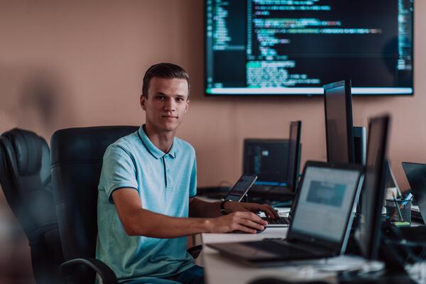 A programmer diligently testing smartphone applications while sitting in their office.