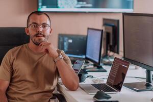 A programmer diligently testing smartphone applications while sitting in their office. photo