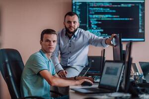 Programmers engrossed in deep collaboration, diligently working together to solve complex problems and develop innovative mobile applications with seamless functionality. photo