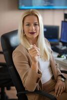 A businesswoman sitting in a programmer's office surrounded by computers photo