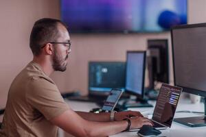 A programmer diligently testing smartphone applications while sitting in their office. photo