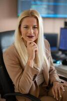 A businesswoman sitting in a programmer's office surrounded by computers photo
