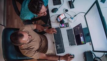 Programmers engrossed in deep collaboration, diligently working together to solve complex problems and develop innovative mobile applications with seamless functionality. photo