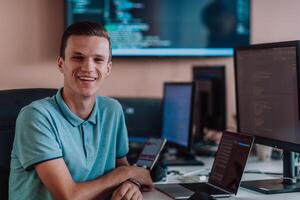 A programmer diligently testing smartphone applications while sitting in their office. photo