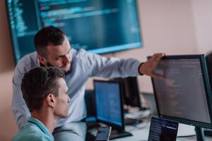 Programmers engrossed in deep collaboration, diligently working together to solve complex problems and develop innovative mobile applications with seamless functionality. photo