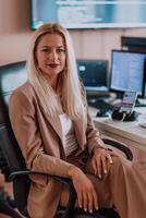 A businesswoman sitting in a programmer's office surrounded by computers, showing her expertise and dedication to technology. photo
