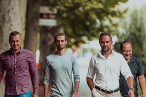After a productive day at work, a group of diverse colleagues enjoy a leisurely stroll through a modern and natural urban setting photo
