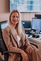 A businesswoman sitting in a programmer's office surrounded by computers, showing her expertise and dedication to technology. photo