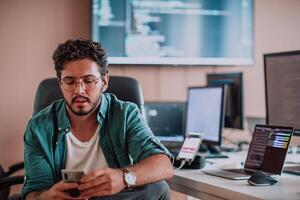 A programmer diligently testing smartphone applications while sitting in their office. photo