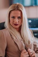A businesswoman sitting in a programmer's office surrounded by computers, showing her expertise and dedication to technology. photo