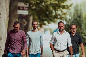 After a productive day at work, a group of diverse colleagues enjoy a leisurely stroll through a modern and natural urban setting photo