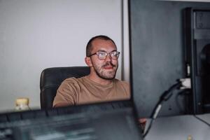 A programmer diligently testing smartphone applications while sitting in their office. photo