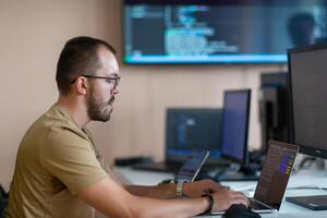 A programmer diligently testing smartphone applications while sitting in their office. photo