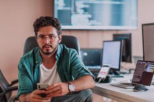 A programmer diligently testing smartphone applications while sitting in their office. photo
