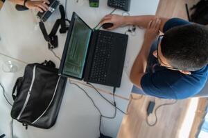 Top view of programmer diligently testing smartphone applications while sitting in their office. photo