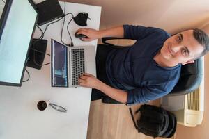 Top view of programmer diligently testing smartphone applications while sitting in their office. photo