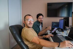 Programmers engrossed in deep collaboration, diligently working together to solve complex problems and develop innovative mobile applications with seamless functionality. photo