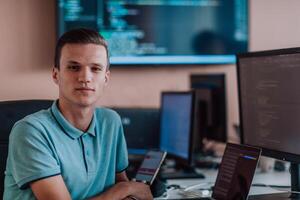 A programmer diligently testing smartphone applications while sitting in their office. photo