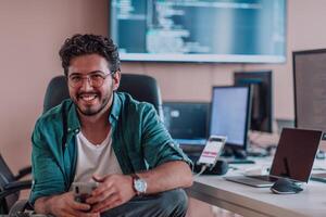 A programmer diligently testing smartphone applications while sitting in their office. photo