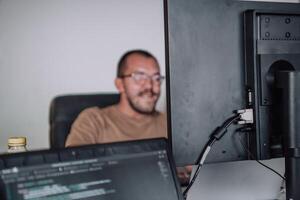 A programmer diligently testing smartphone applications while sitting in their office. photo